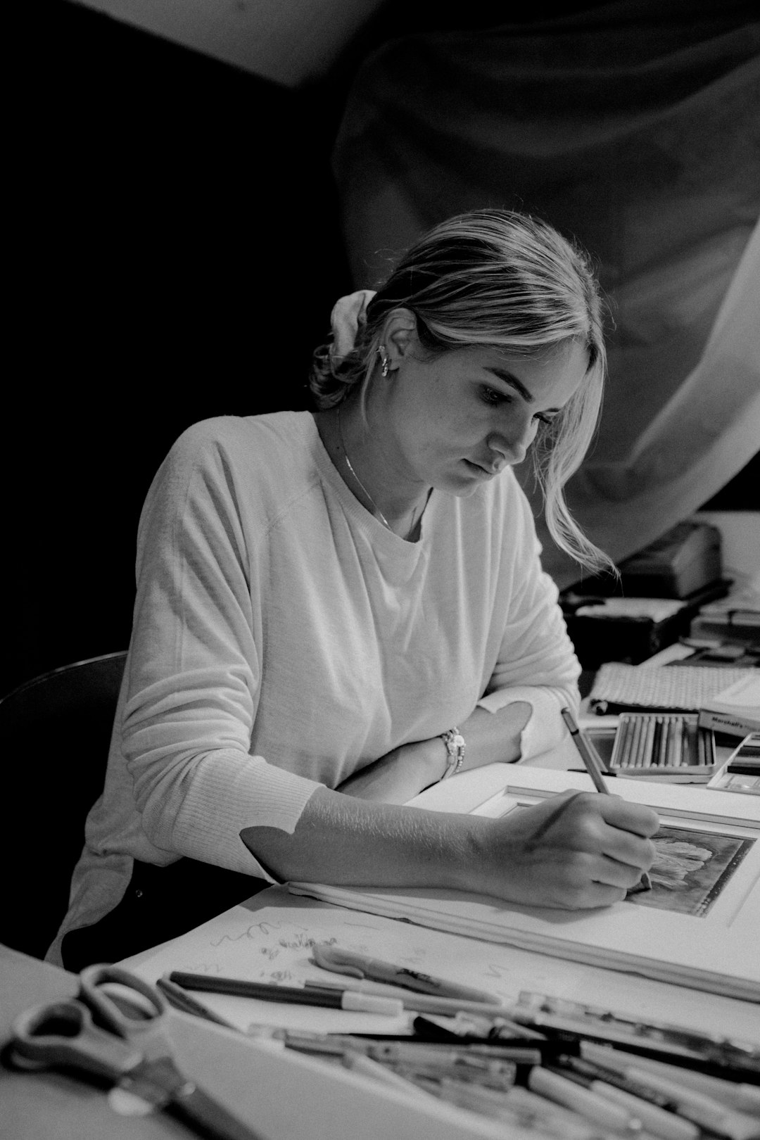 woman in long sleeve shirt writing on notebook