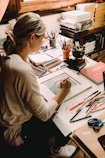 woman in gray long sleeve shirt writing on white paper