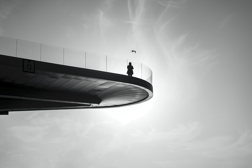 man in black jacket and pants standing on top of building