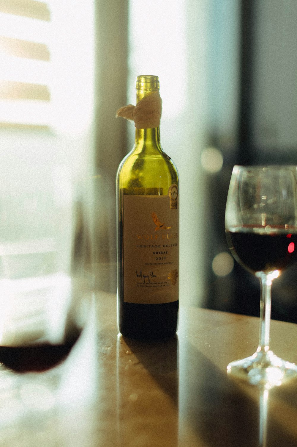 white labeled bottle beside wine glass on table