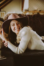 A stylish woman wearing a soft boho chic cardigan, smiling confidently in a sunlit cozy room.