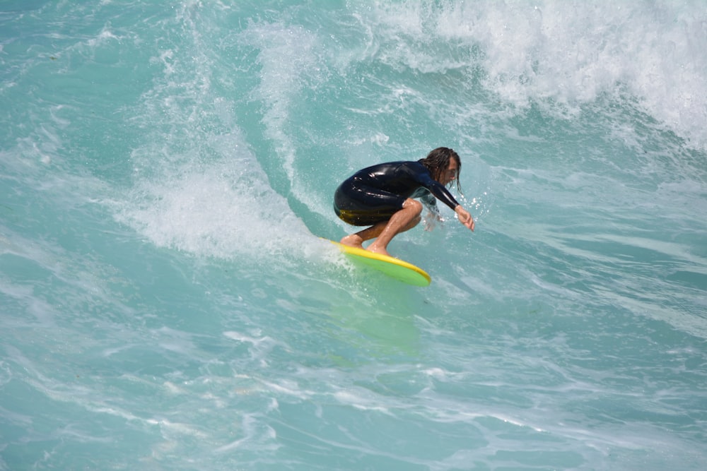 man surfing on sea waves during daytime