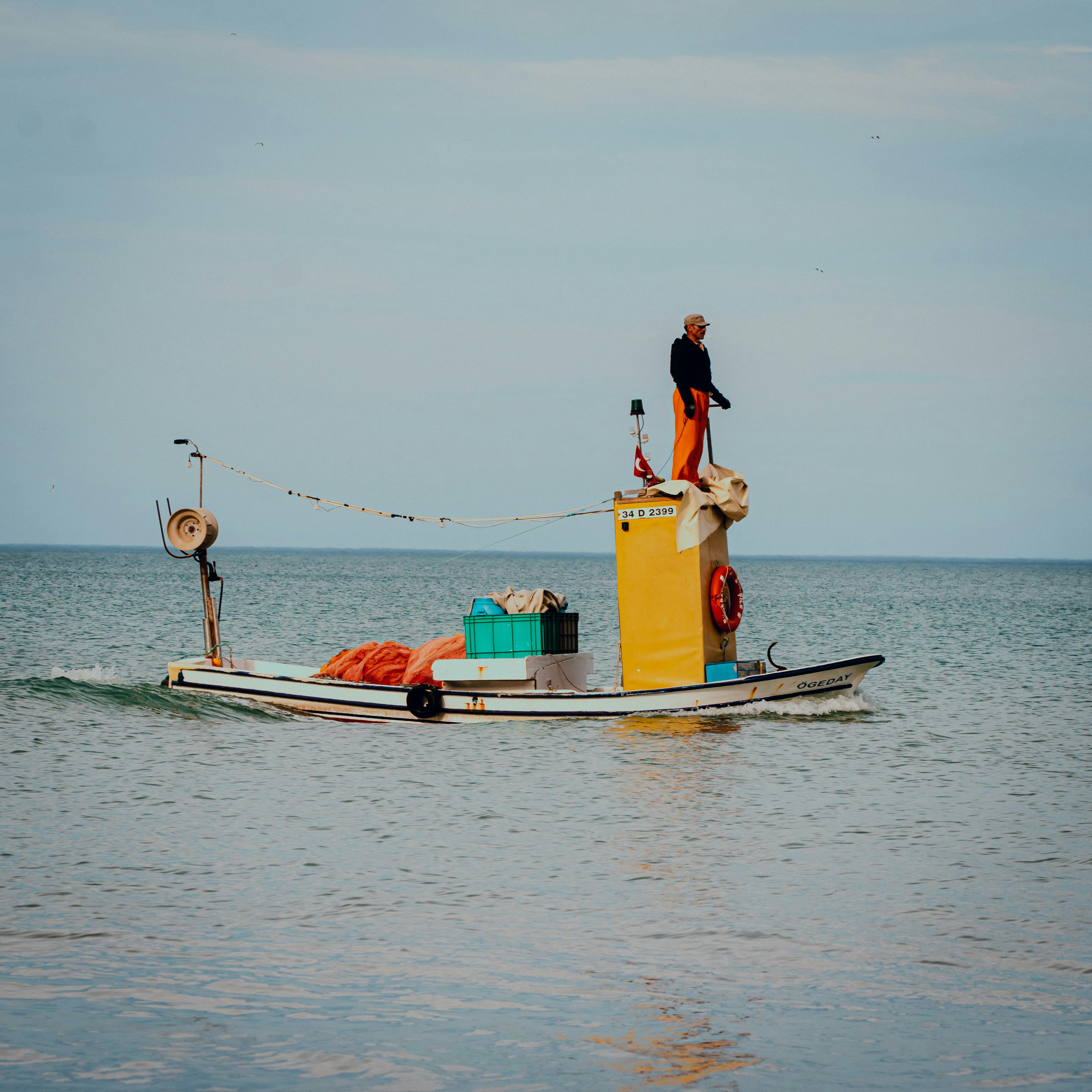 man and woman on yellow and white boat on sea during daytime
