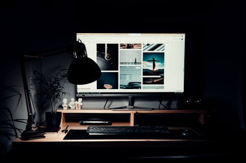 black flat screen computer monitor on brown wooden desk