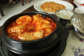 A bowl of steaming hot Korean chicken stew with vegetables and rice.