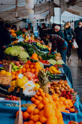 people standing on street with fruits and vegetables