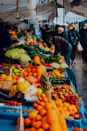 people standing on street with fruits and vegetables