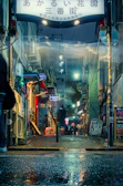 A vibrant painting capturing neon signs flickering in a rainy urban alley.