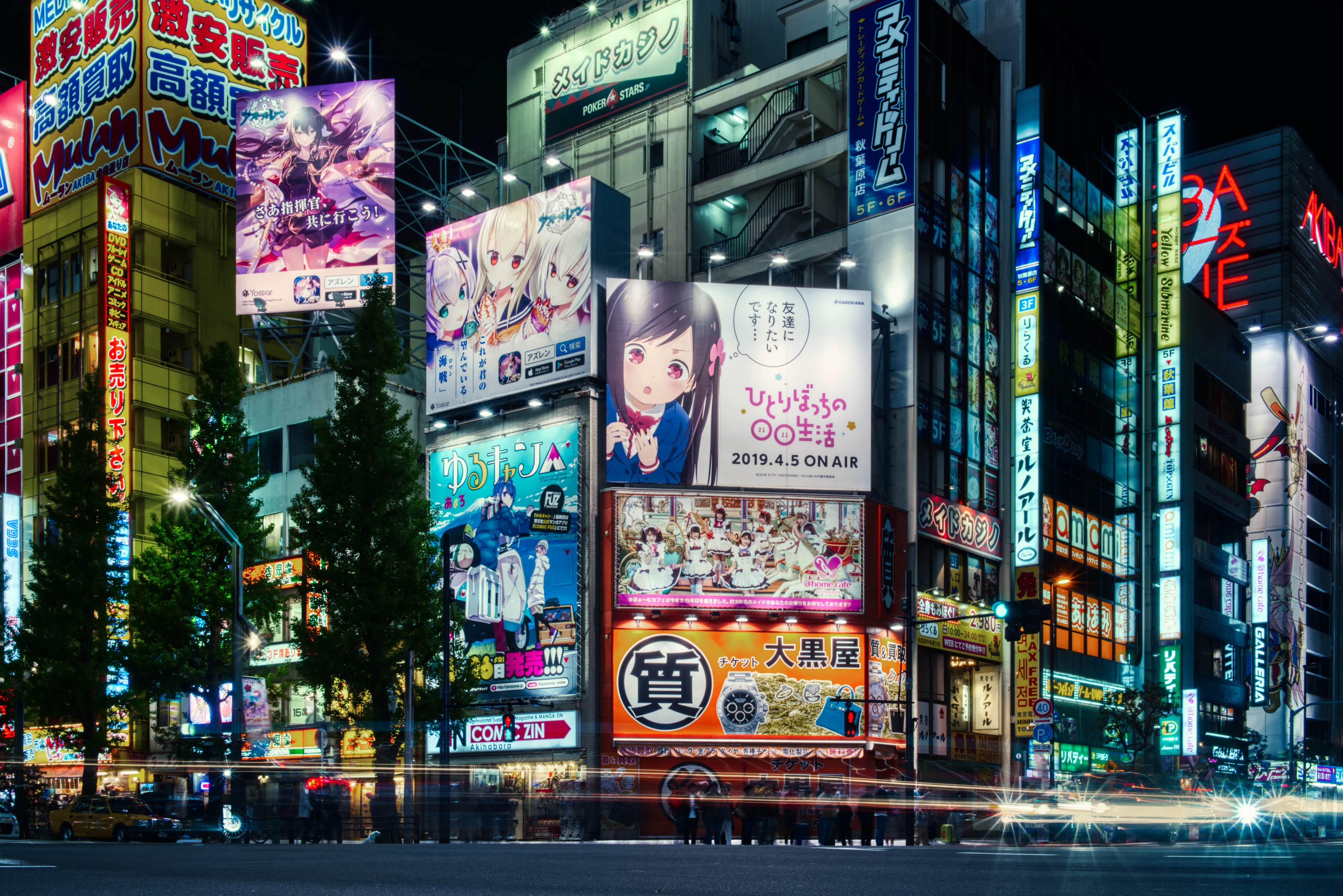 Panneaux publicitaires d'anime illuminés sur les façades d'Akihabara, la nuit