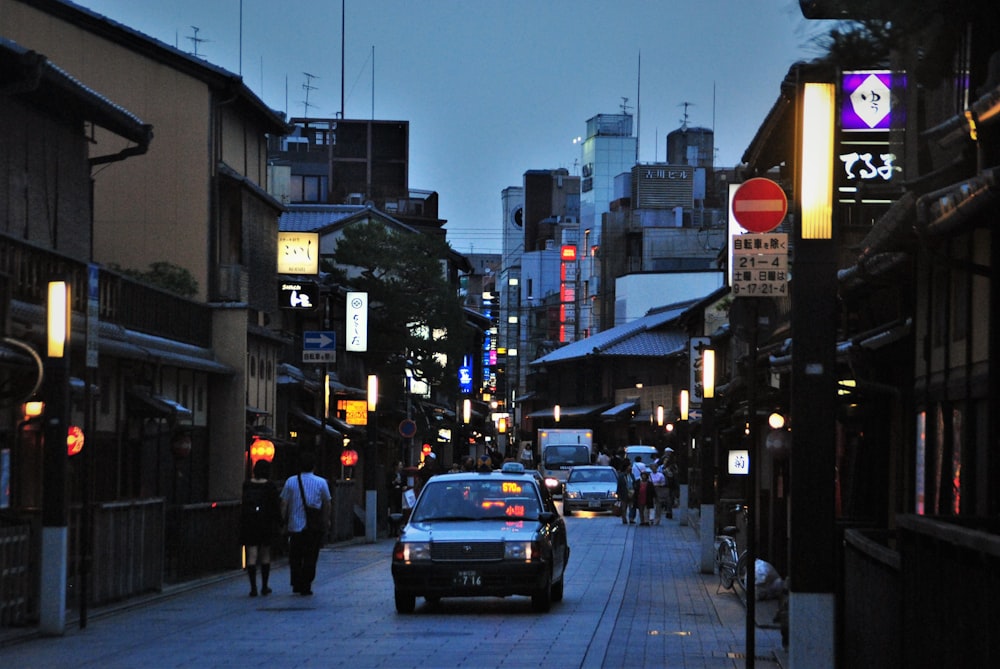 people walking on sidewalk during night time