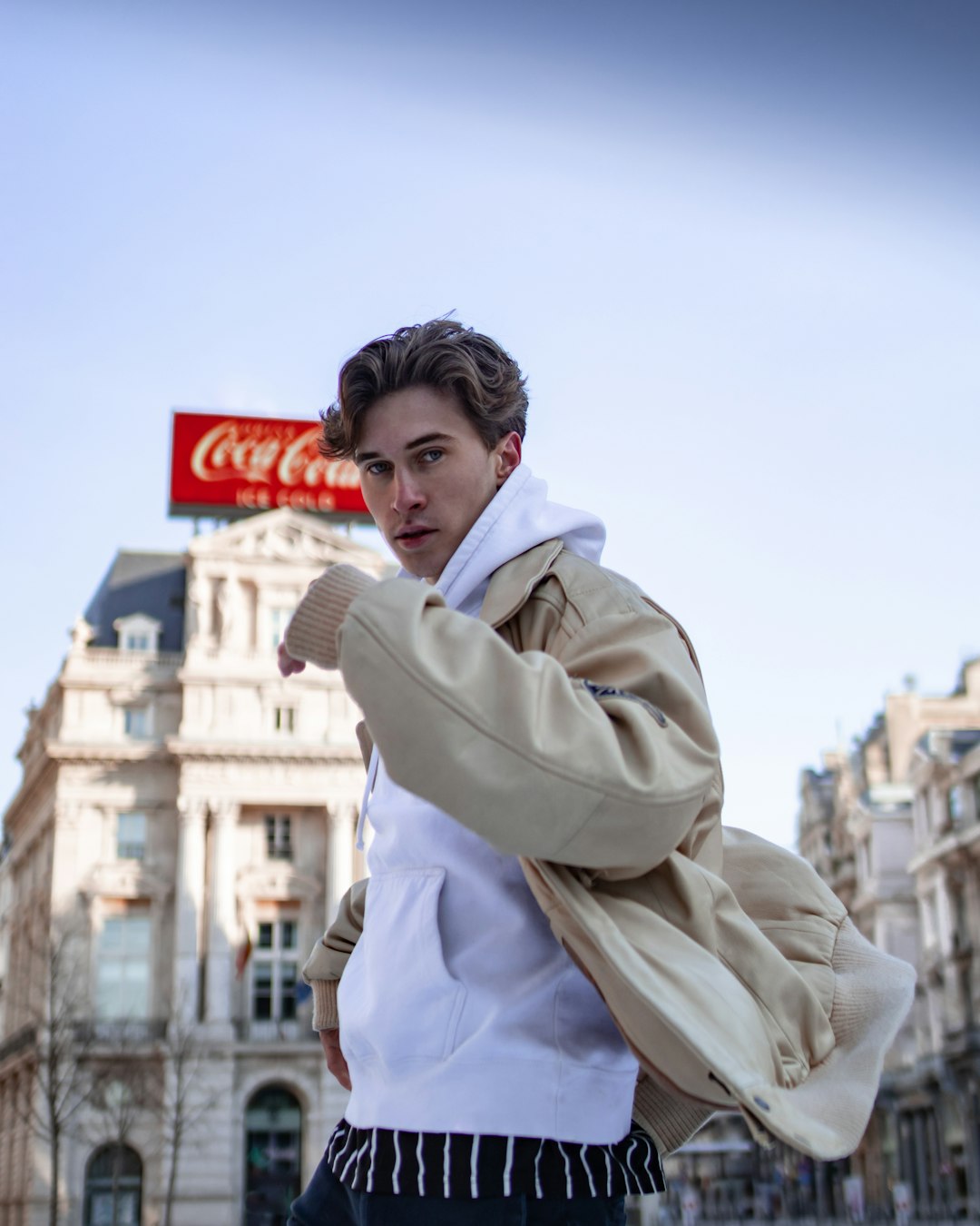 man in white coat standing near building during daytime