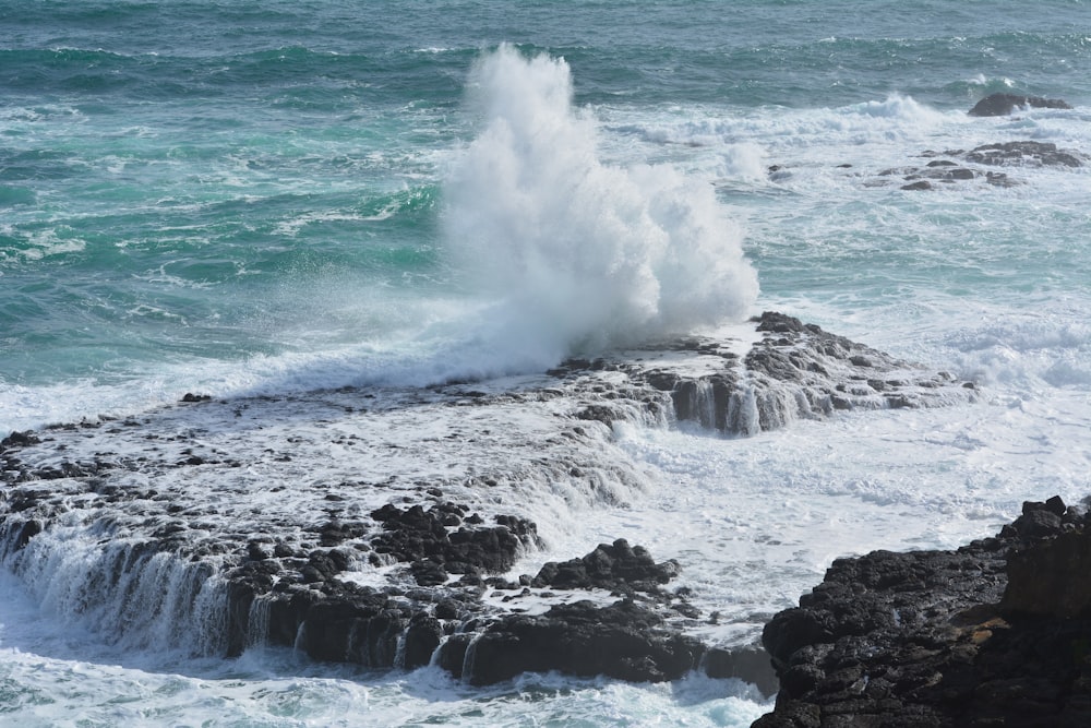 ocean waves crashing on rocky shore during daytime