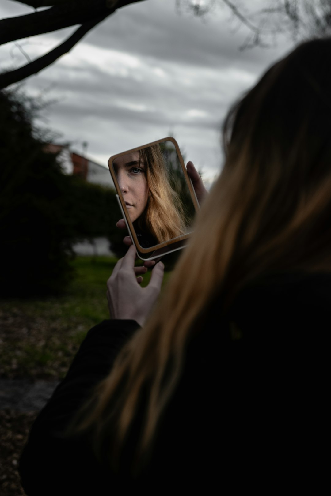 woman in black jacket holding iphone