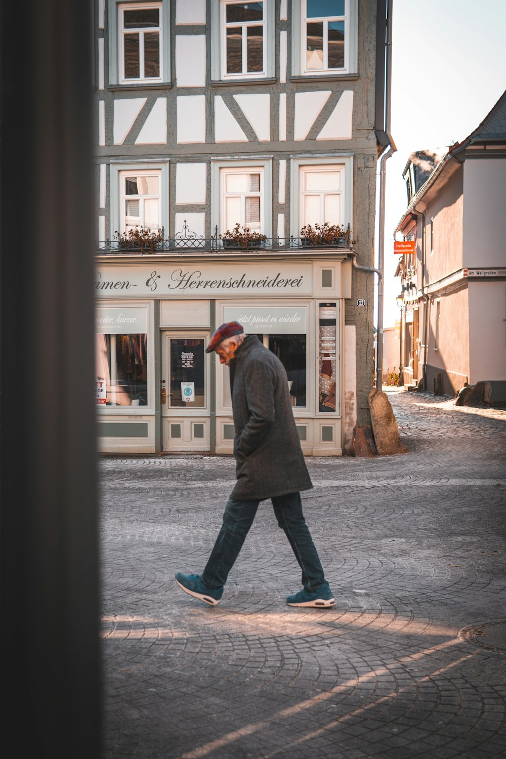 man in black coat standing in front of store