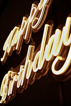 Photo corner featuring a white satin backdrop with a soft pink neon 'Happy Birthday' sign.