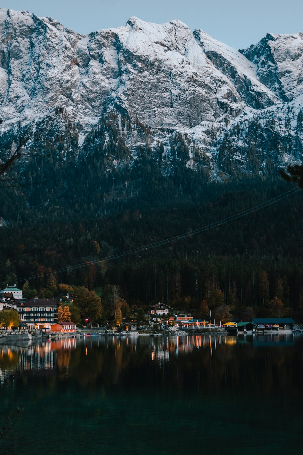 white and brown building near body of water and mountain