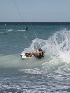 Close-up of a kiteboard carving through crystal clear blue water with spray flying.