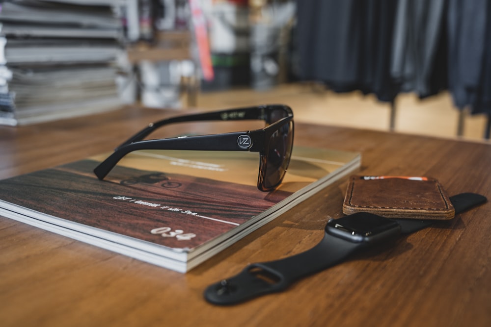 black framed sunglasses on brown book