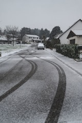 A quiet residential driveway freshly cleared of snow in early morning light.