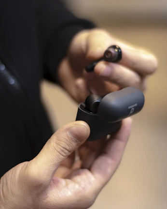 A customer happily testing out a new pair of wireless earbuds inside the nexacell store.
