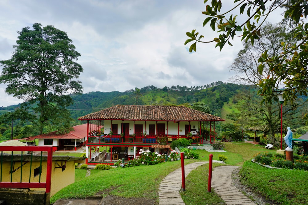 brown wooden house near green trees under white clouds during daytime