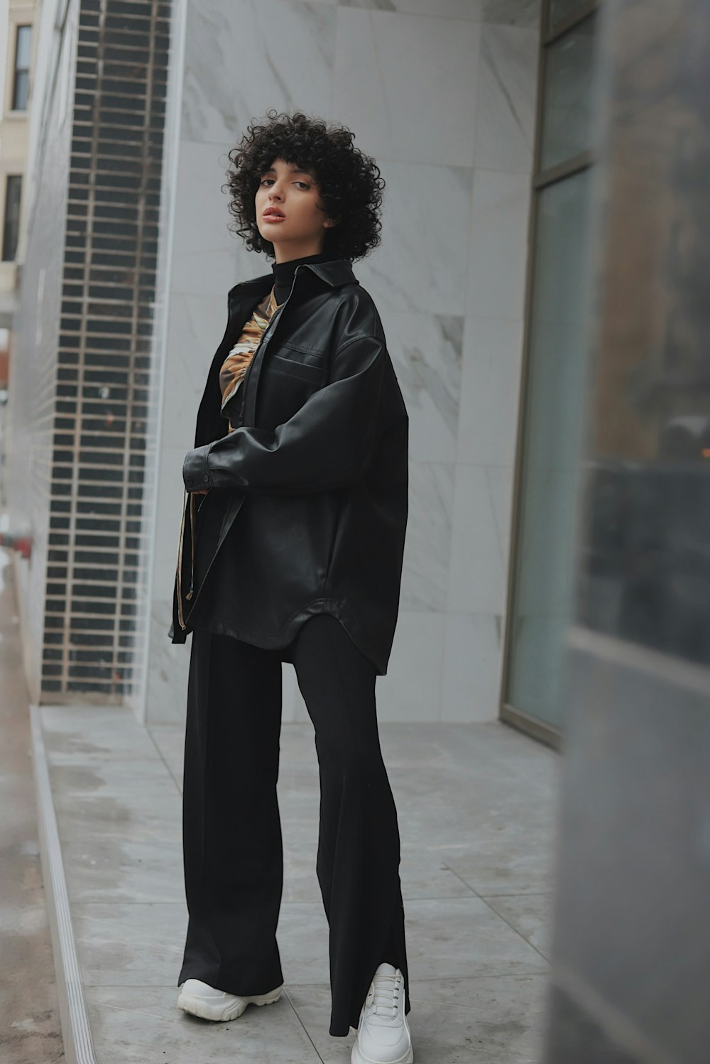 woman in black coat standing on white floor