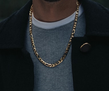 man in black coat wearing gold necklace