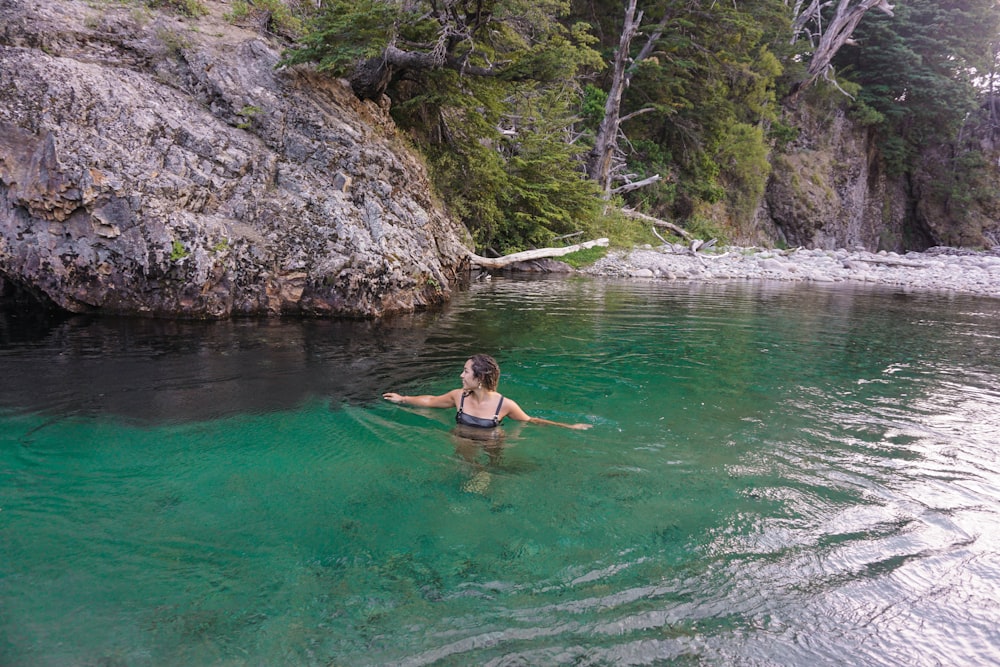 Mujer en bikini azul nadando en el agua durante el día