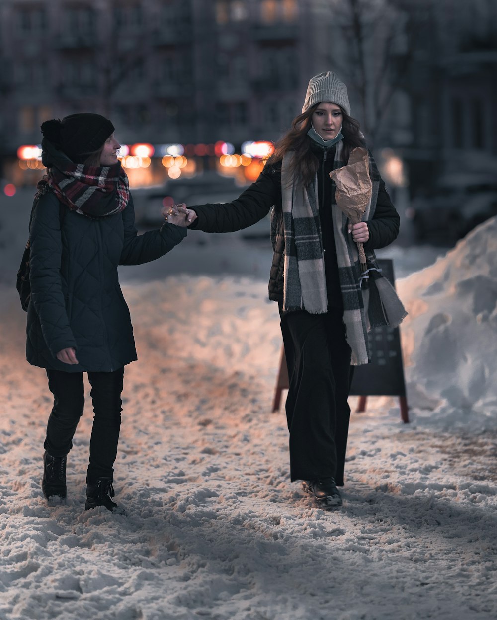 woman in black coat standing on snow covered ground during daytime