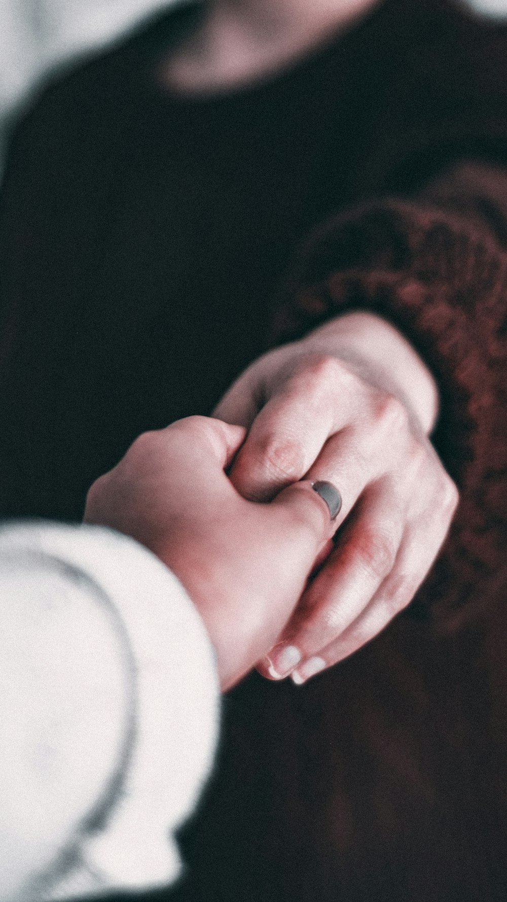 person in white long sleeve shirt holding silver ring