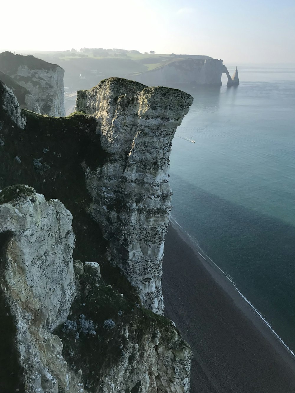 person standing on rock formation near body of water during daytime