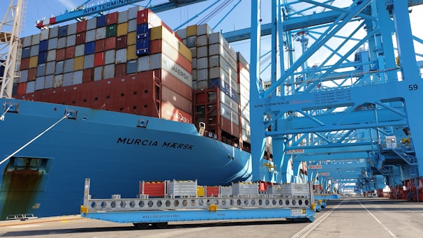 Container ship docked at UK port with greeteasy ltd branding.