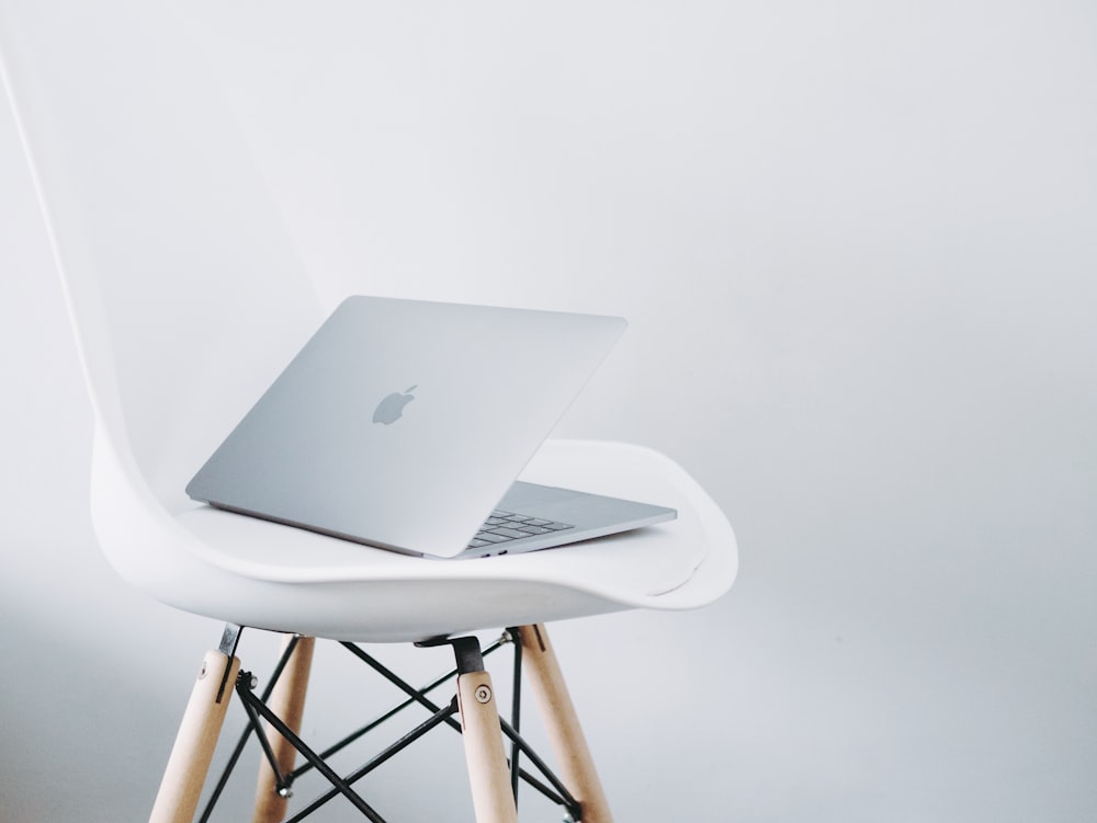 MacBook plateado sobre mesa blanca