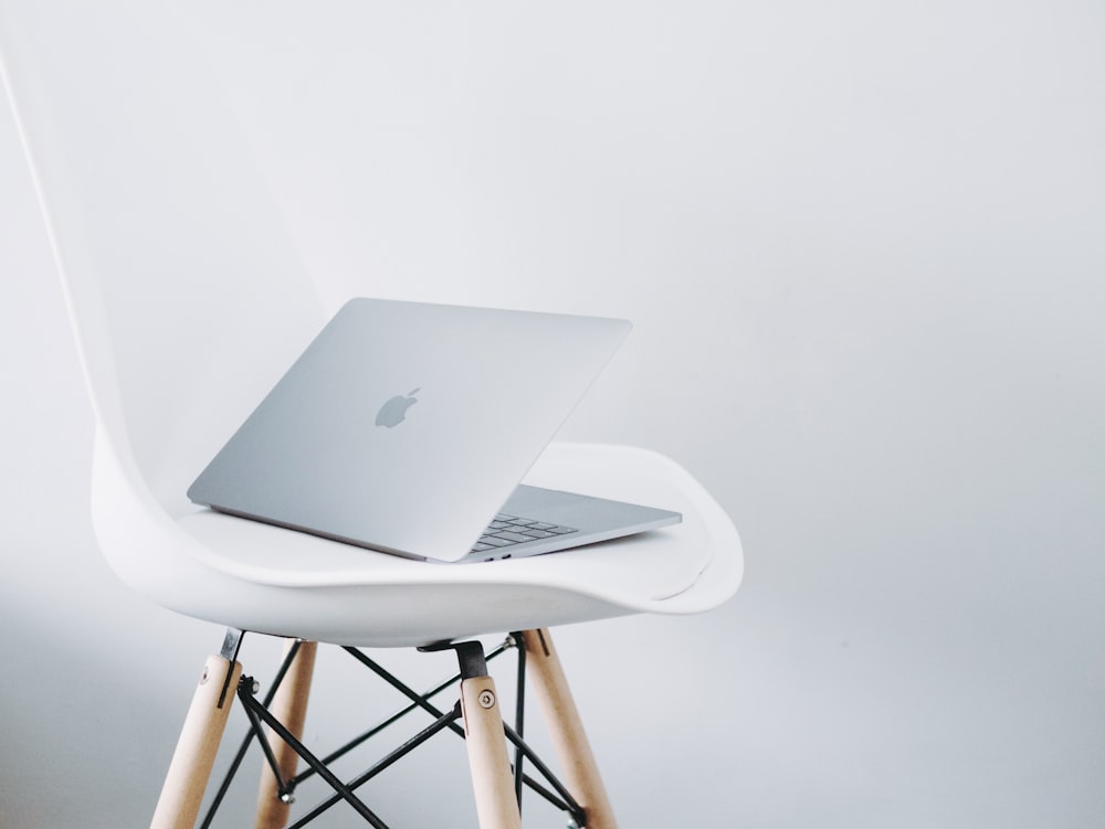 MacBook argenté sur table blanche