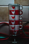 Stack of festive mugs featuring playful Canadian icons on a bright kitchen counter.