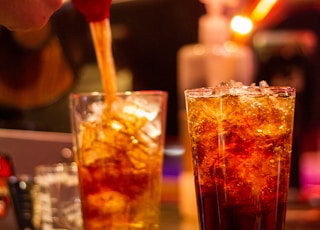 clear drinking glass with orange liquid and ice