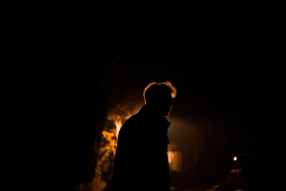 silhueta do homem em pé na frente de uma luz