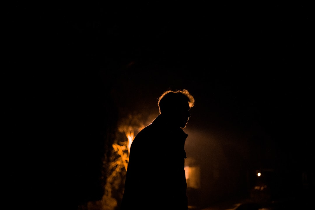 silhouette of man standing in front of a light