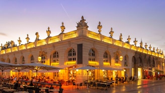 An elegant dining setup on a rooftop terrace overlooking a historic European city at twilight.