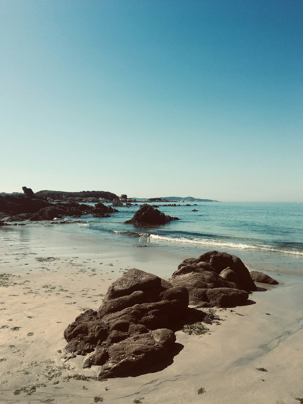 person standing on rock formation near sea during daytime