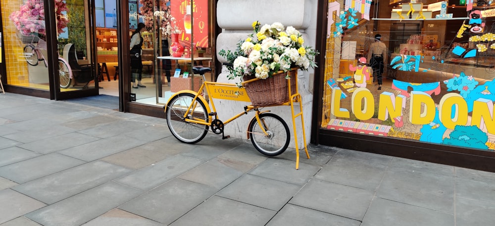 yellow city bicycle with basket of flowers
