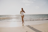 woman in white bikini standing on beach during daytime