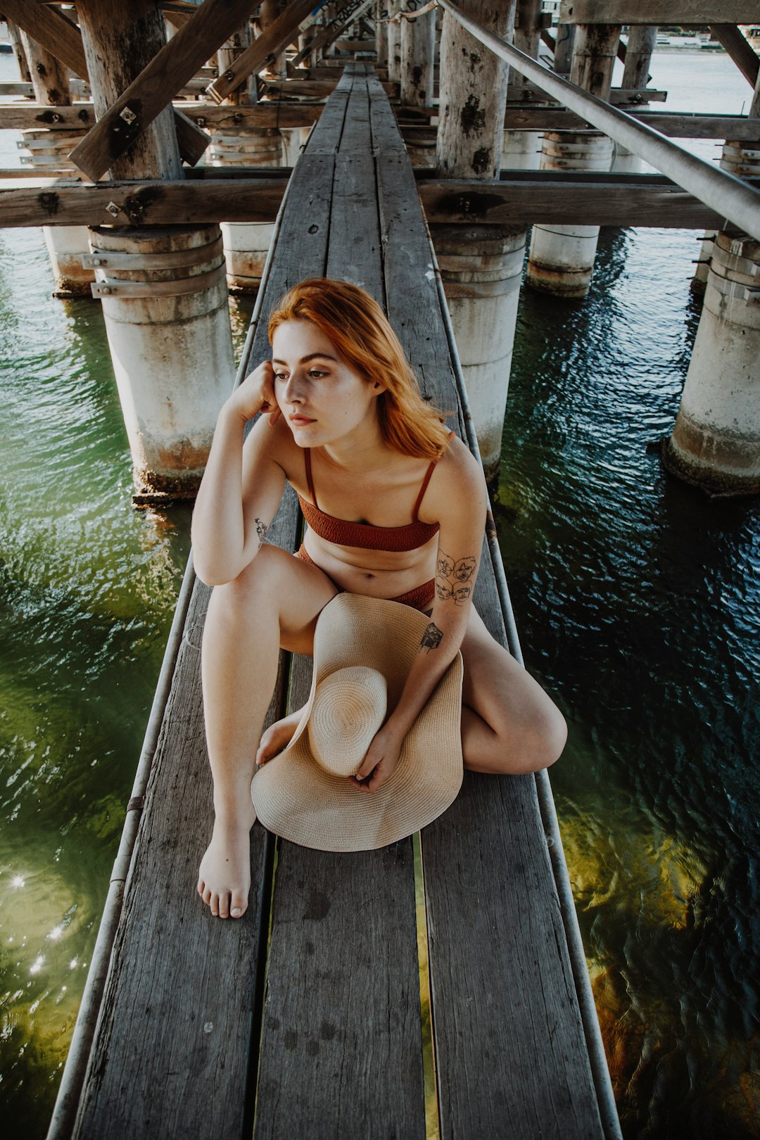 woman in brown sun hat sitting on brown wooden boat