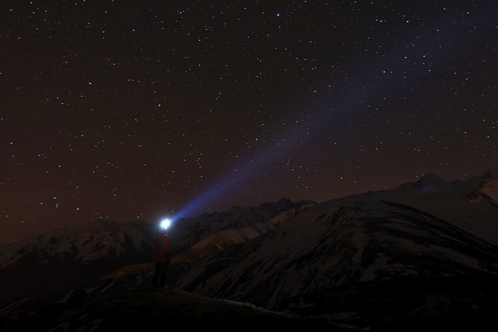 silhouette of mountain under starry night