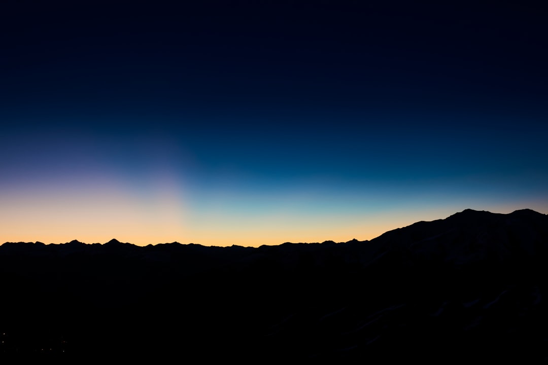 silhouette of mountain under blue sky during night time