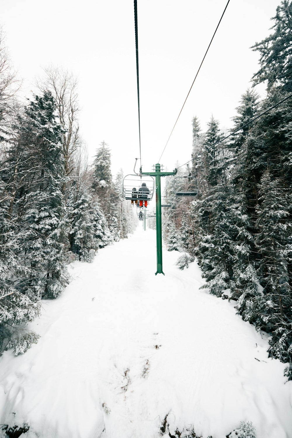 green cable car over snow covered ground