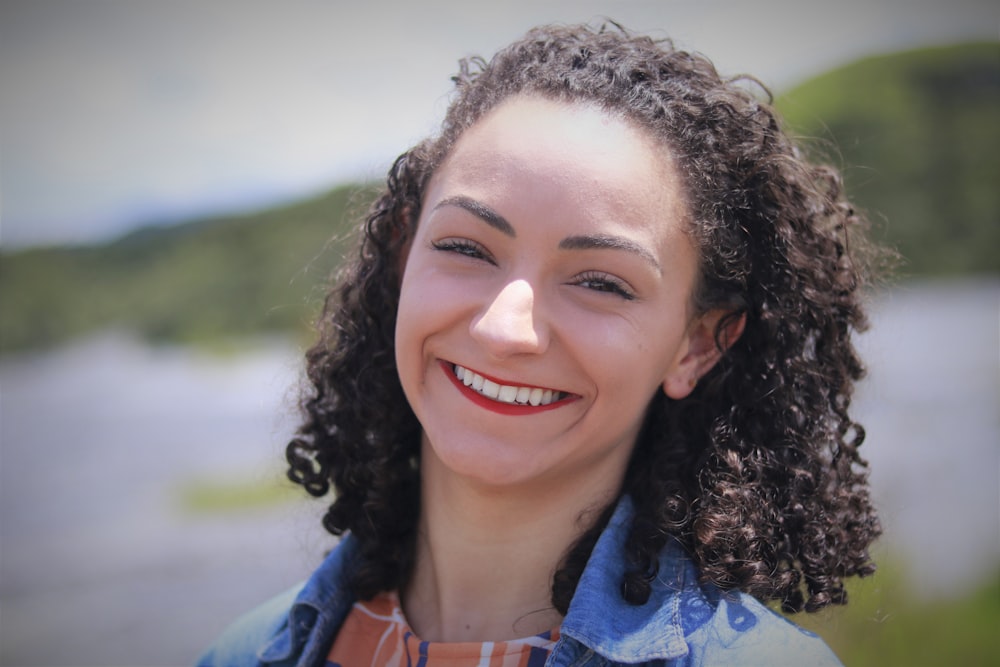 woman in blue and white floral shirt smiling