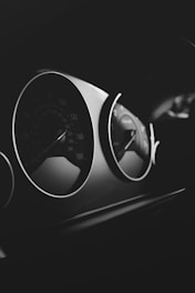 grayscale photo of car steering wheel