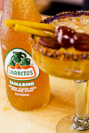 Bright tamarindo and lulo sachets displayed with ice cubes and a splash of water, highlighting freshness.