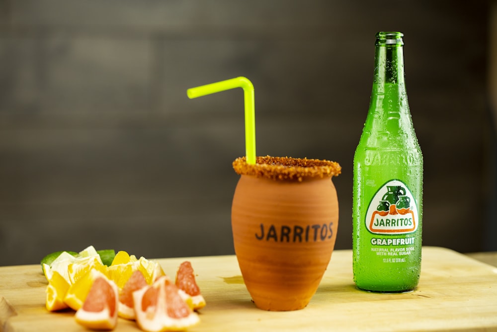 brown wooden vase beside green plastic bottle